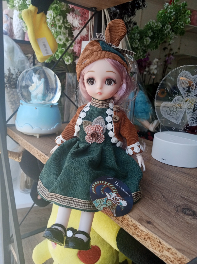 Yeşil elbiseli oyuncak bebek 